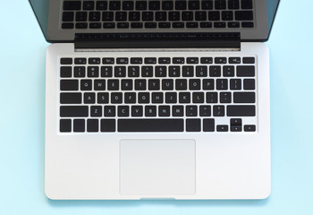 Modern laptop on blue background, top view