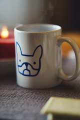 Tasse Kaffe mit Keks und Kerze