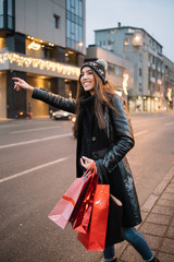 Happy girl waving hand and catching taxi