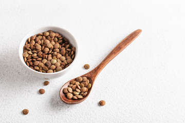lentils in a white Cup on wooden background with spoon