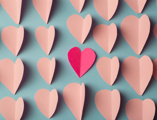 Love (Valentine's day) background or wedding background. Pink and red paper hearts on a blue pastel background. Love concept