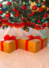 Boxes with gifts on a light, blue background and under the Christmas tree. Gift in the hand. Christmas presents, Nicholas Day, Valentine's Day. Bright boxes with bright ribbons Gifts in Macro.