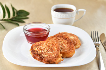 Fritters on a white plate with cherry sauce