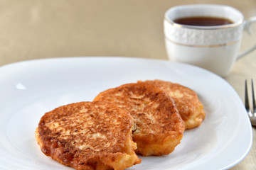 Fritters on a white plate with cherry sauce