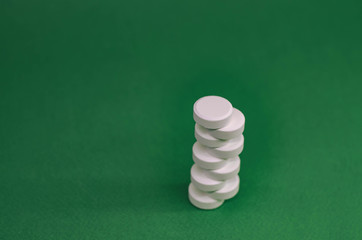 tower of white tablets on a green background