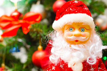 Toy Santa Claus, on the background of the New Year tree, and on the background of the New Year star on the Christmas tree. Toy Santa in close-up. Christmas decoration. Celebration.