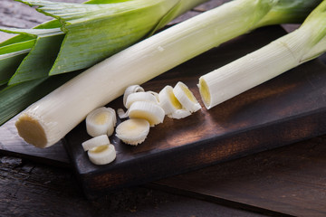 Fresh raw leek slices on wooden  background. Ripe onion