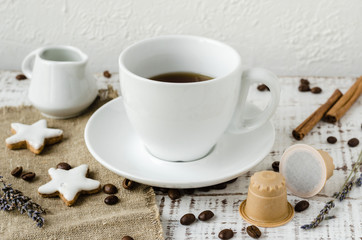 Te cup of coffee with wooden coffee capsules, lavander and coffee beans on white wooden background. Coffee capsule made of wood. Zero waste and no plastic concept. Eco coffee capsules