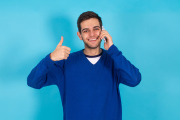 casual young hipster man with mobile phone isolated on color background