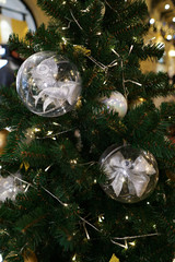 Christmas decorations on the Christmas tree. Transparent balls with a bow inside.