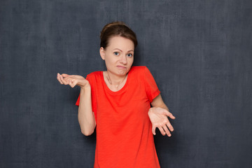 Portrait of bewildered woman raising hands and shrugging shoulders