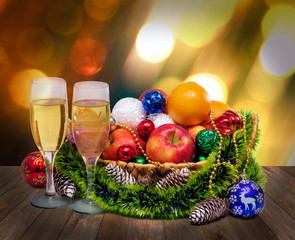 Fototapeta na wymiar champagne glasses fruits apples and tangerines Christmas tree toys balls cones in Christmas basket