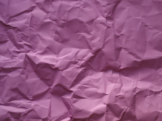 Pink crumpled wrinkled textured paper background.