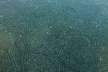 Beautiful color and pattern on ice. Beautiful background. There is an unusual pattern on the ice. Nature as an artist