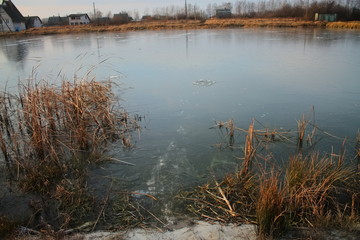 The first ice on the lake, a beautiful view of the frozen lake. The first smooth clean ice on the lake. It is dangerous to walk on thin ice. The lake was covered with thin transparent ice.