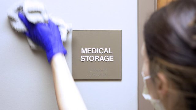 Slider movement of janitor woman cleaning Medical storage sign on wall in medical office, hospital, doctors office. 