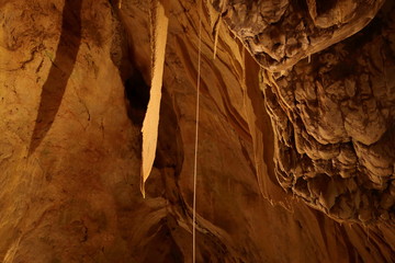 Caving and exploring amazing underground caves with beautiful geological rock formations of speleothems, stalactites and stalagmites