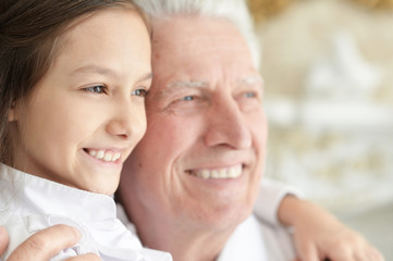 Portrait of happy elderly man with cute granddaughter