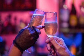 Woman and man toasting with two champagne glasses