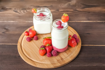 Homemade yogurt in a jar close-up. Fermented milk product with strawberries and copy space.