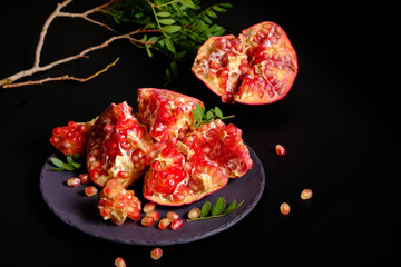 Pomegranate with Christmas decorations on dark background