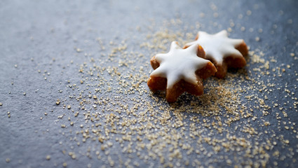 Cinnamon stars. Christmas cookies with brown sugar on dark stone background. 