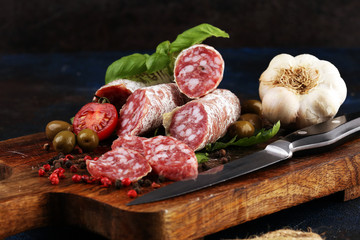 thinly sliced salami on a wooden texture on the background.