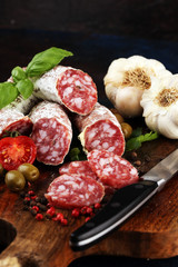 thinly sliced salami on a wooden texture on the background.