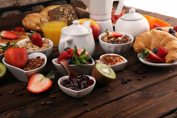 Breakfast served with coffee, orange juice, croissants, cereals and fruits. Balanced diet. Continental breakfast with granola and fruits