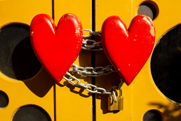 Two hearts chained together and kept together with a lock, metaphor for commitment