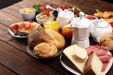 Breakfast served with coffee, orange juice, croissants, cereals and fruits. Balanced diet. Continental breakfast with granola and fruits