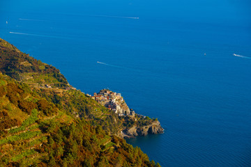 Colorful traditional houses on a rock over Mediterranean sea on sunset, Manarola, Cinque Terre, Liguria, Italy. Colors of amazing little Italian village on mountain. Quiet sky and peaceful sea.