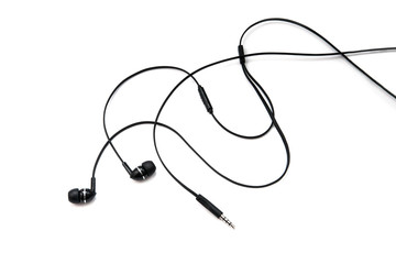 Earphones headset. In-ear headphones. Vacuum wired black headphones for listening to music and sound on portable devices on a white background. Ear plugs for music lovers.