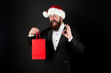 Perfect gift. Happy businessman show OK sign. Bearded man smile with gift in bag. Shopping for Christmas gift. Boxing day. New year surprise. Office party. Gift from boss to empoyees, copy space