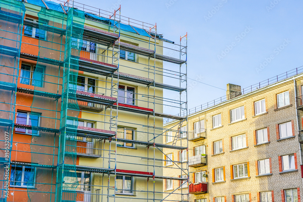 Wall mural scaffolding arround the house to install thermal insulation of the apartment building facade