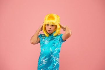 japanese kimono. child national costume of japan. small girl traditional eastern clothes. asian girl yellow hair wig. chinese carnival. pazzled kid pink background. punchy pastels