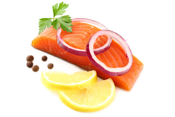 Red fish. Raw salmon fillet with parsley, peppercorns, onion slices and lemon isolate on white background.