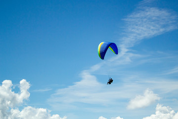 Paraglider in the blue sky. The sportsman flying on a paraglider.