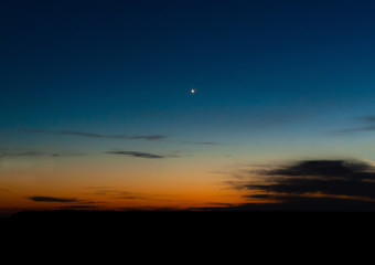 a single bright shiny star on a colorful night or morning sky