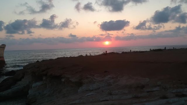 Beautiful sunset by the sea, ship, cliffs, Cyprus, Mediterranean Sea. Drone shooting