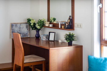 Close-up of wooden table and chair in corner of bedroom.