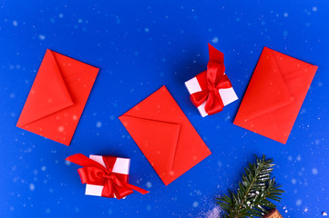 Mockup on a blue background with red envelopes and white christmas gift boxes. Banner. Long format. Copy space.