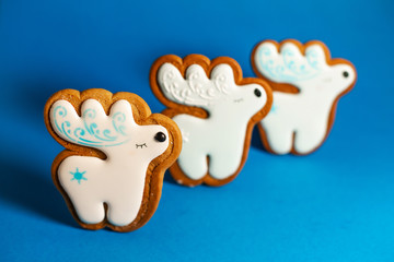 gingerbread cookie of cute deer on blue background. Traditional Christmas food. Christmas and New Year holiday concept.