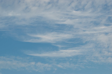 Cirrus clouds sprawling across the blue sky with beautiful white flakes and threads