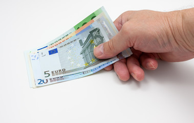 Various euro banknotes held in a hand on white background