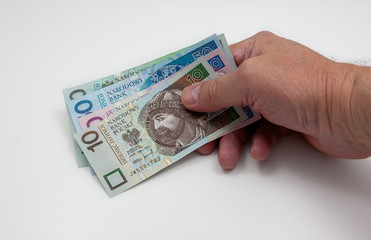 Polish zloty banknotes held in a hand on white background