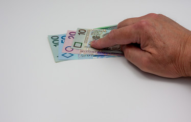 Polish zloty banknotes pressed down to the table with the index finger