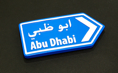 A directional arrow showing the way to Abu Dhabi.
