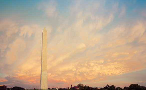 Panorama of the Washington Monument during sunset with the clouds behind the monument lite in brilliant evening colors.
