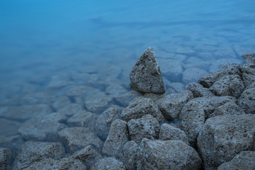 Natural shore of lake with patterns of rocks